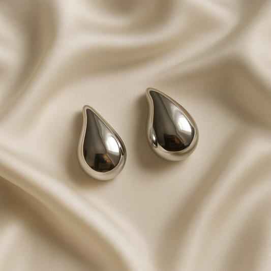 Elegant Teardrop Silver Earrings on Luxe Fabric Backdrops – Product Photography Series
